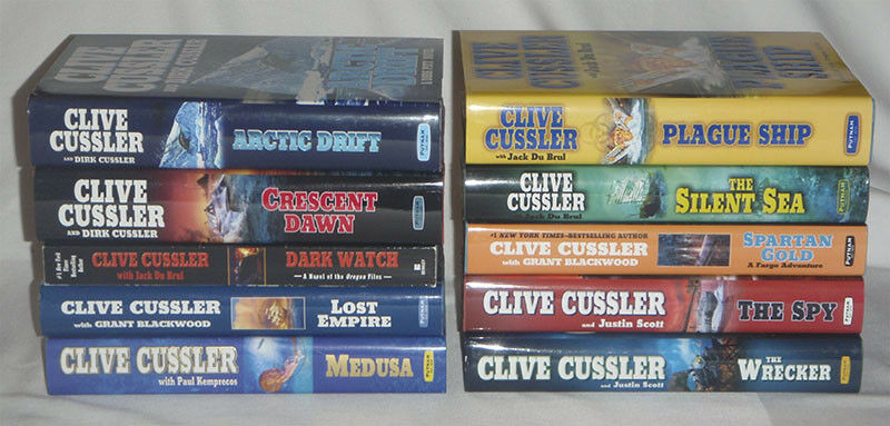 pick one - Clive Cussler - DIRK PITT - hardcover books - HC DJ firewood - one pb - Fresh Stock Dated January 2026